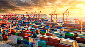 Cargo containers and container cranes with sunset background