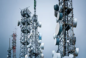 Two communications towers with a blue sky in the background