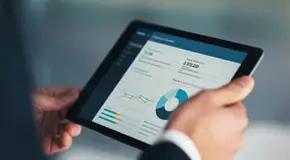 Person holding a tablet with data on the screen
